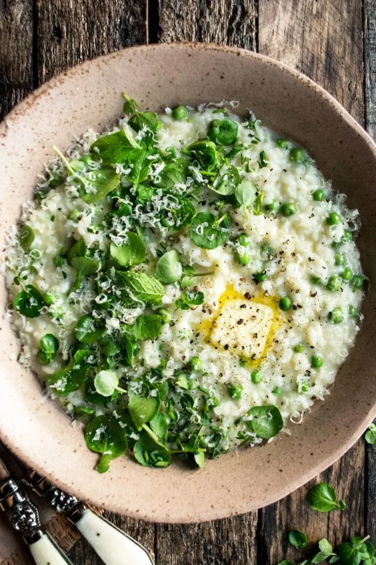 Creamy spring pea risotto with parmesan cheese and fresh basil leaves