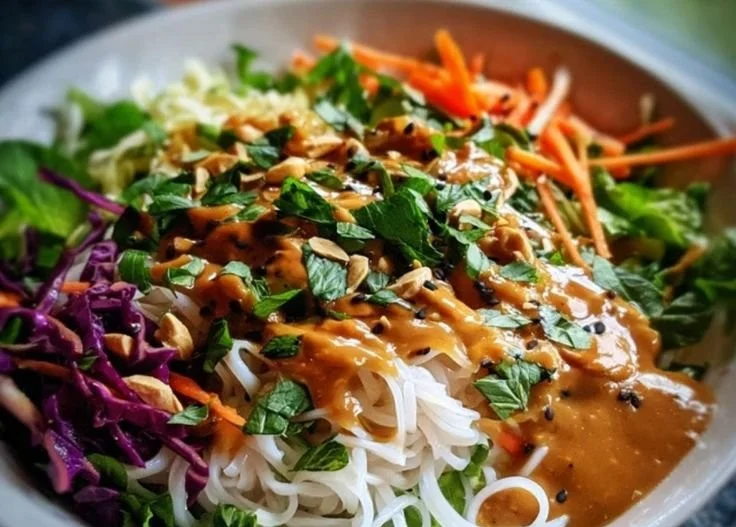 Spring Roll Salad topped with peanut dressing, featuring fresh veggies and herbs.