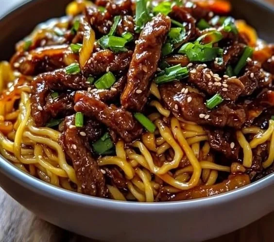 Delicious sticky beef noodles served in a bowl with garnish