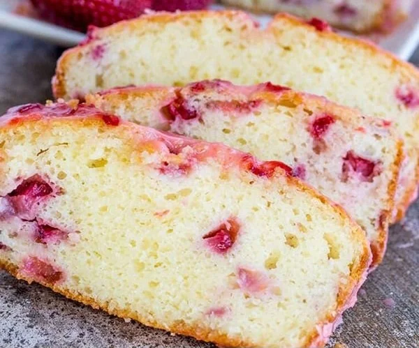 Freshly baked strawberry pound cake topped with strawberries and cream