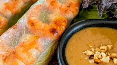 Thai shrimp rolls served with creamy peanut sauce on a plate
