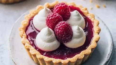 Vegan raspberry curd tarts garnished and ready to serve, perfect summer dessert.
