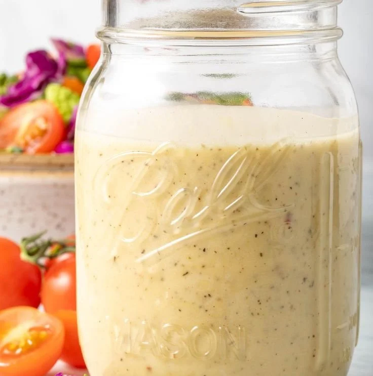 Bowl of delicious creamy vinaigrette dressing drizzled on a fresh salad