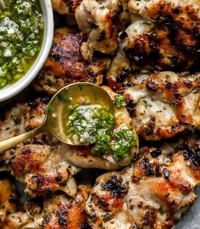 Grilled chimichurri chicken garnished with fresh herbs and spices