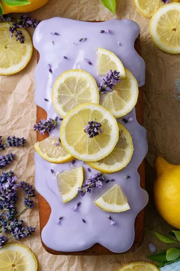Slice of delicious Lemon Lavender Cake with lemon zest and lavender sprigs.