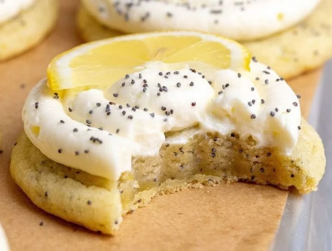 Freshly baked lemon poppy seed cookies on a plate, showcasing their bright yellow color.