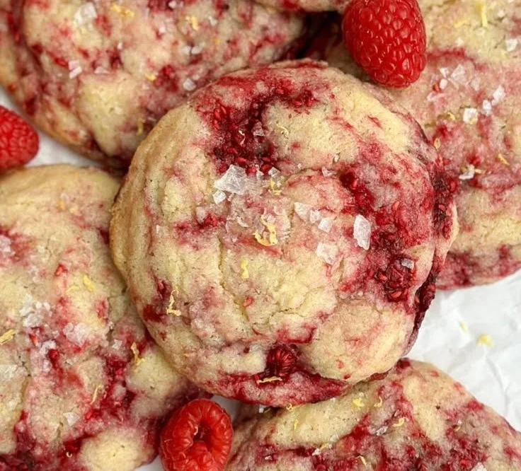 A plate of freshly baked lemon raspberry cookies garnished with raspberries