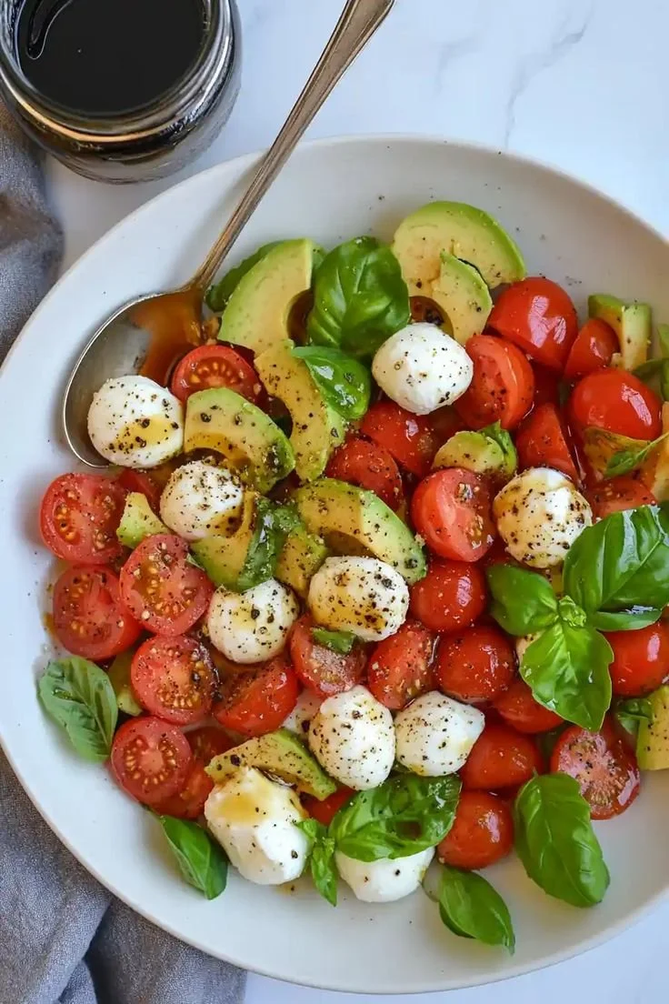 Light Avocado Caprese Salad with tomatoes, basil, and creamy avocado slices.