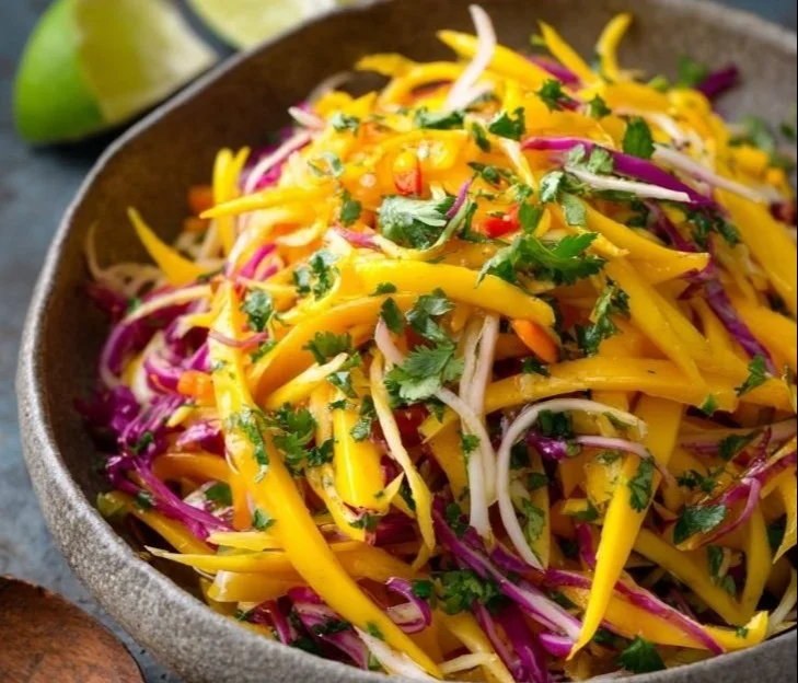 Fresh mango slaw salad with colorful vegetables in a bowl