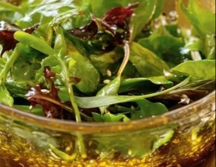 Homemade Maple Balsamic Vinaigrette in a glass jar with fresh ingredients