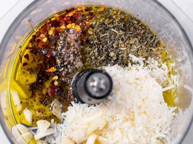 Bottle of homemade Parmesan Vinaigrette dressing on a salad plate.