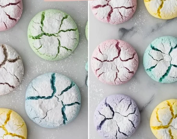 Pastel crinkle cookies dusted with powdered sugar on a baking tray