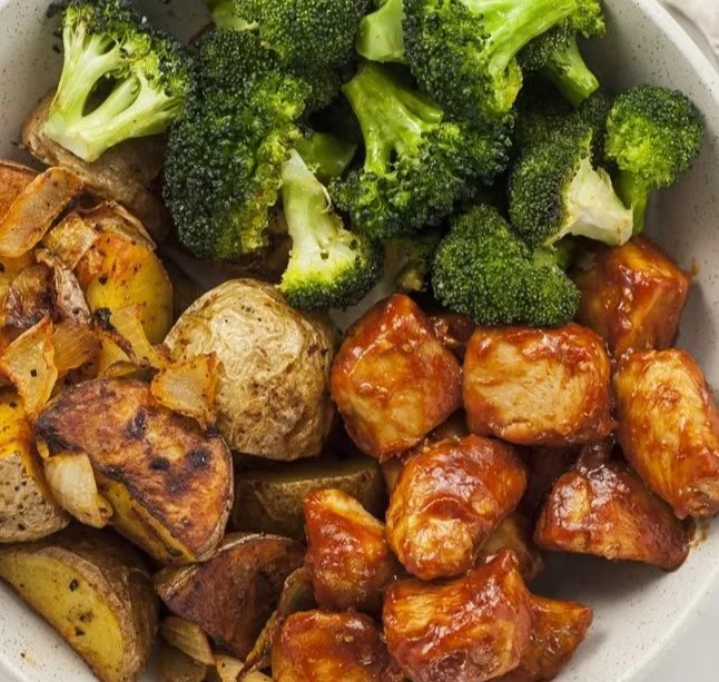 Skinny chicken and roasted potato bowl with fresh vegetables and herbs