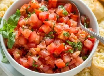 Plate of authentic Italian Bruschetta with tomatoes and basil on toasted bread.