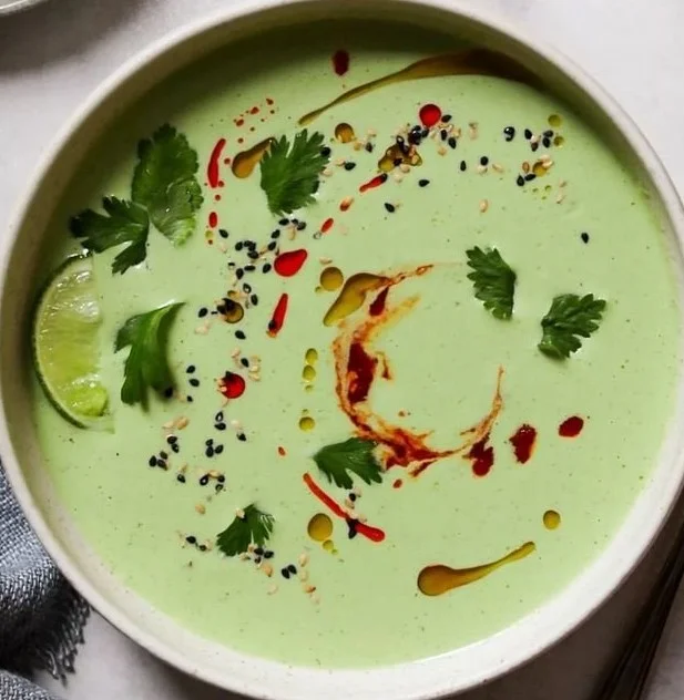 Chilled cucumber soup garnished with chili and lime in a bowl