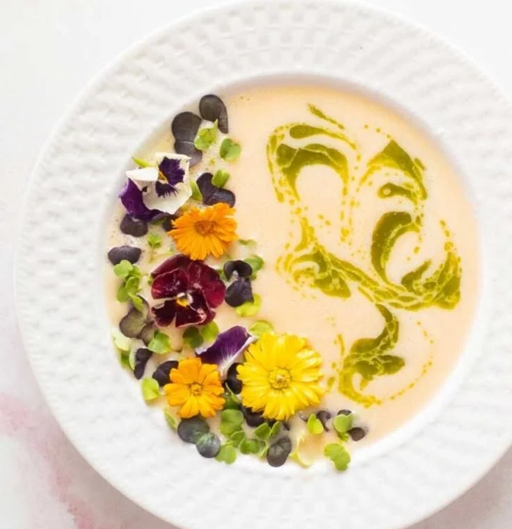 Bowl of chilled peach soup garnished with mint leaves.