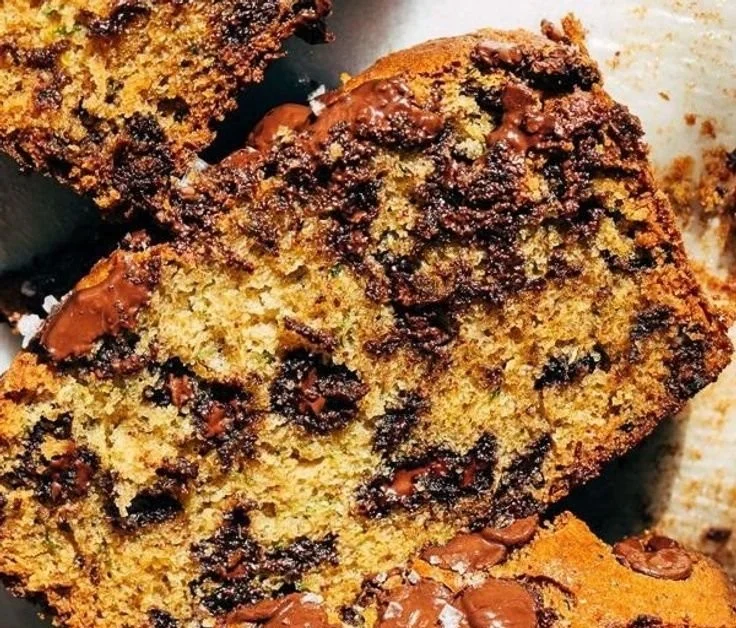 Homemade chocolate chip zucchini bread sliced on a wooden board.