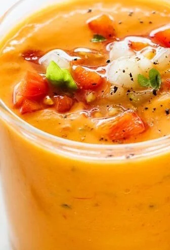 Bowl of classic gazpacho garnished with fresh veggies and herbs