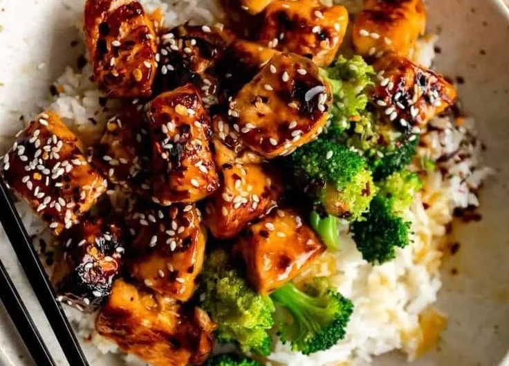Crispy Orange Salmon Bowl with vegetables and rice on a plate