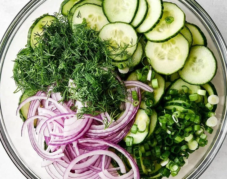Fresh cucumber salad with herbs and dressing on a plate