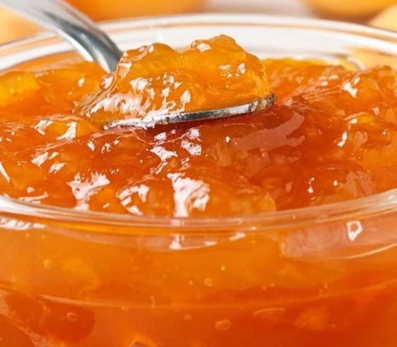 Jar of easy apricot jam with fresh apricots and toast