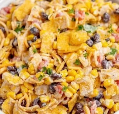Bowl of colorful Frito corn salad topped with fresh ingredients