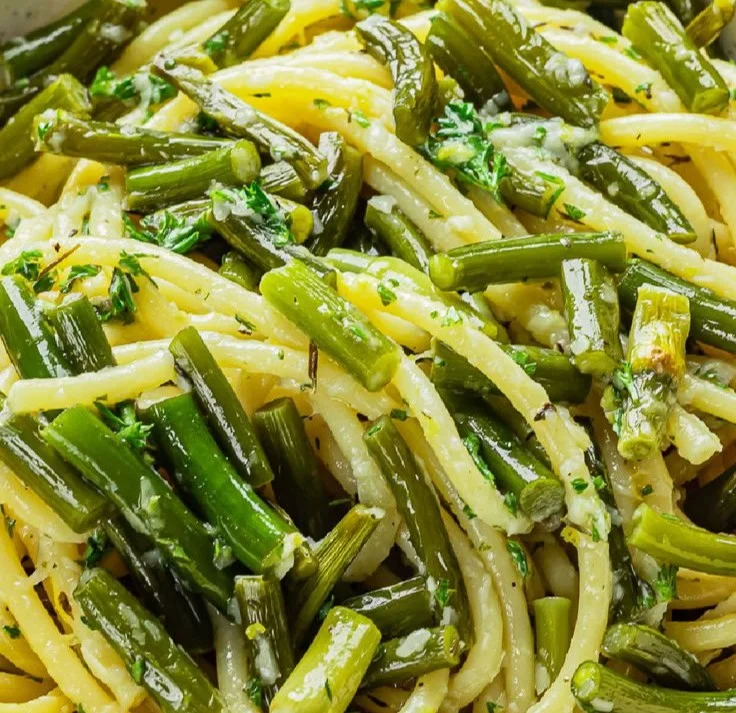 Vegan Garlic Scape Pasta topped with fresh herbs and vegetables
