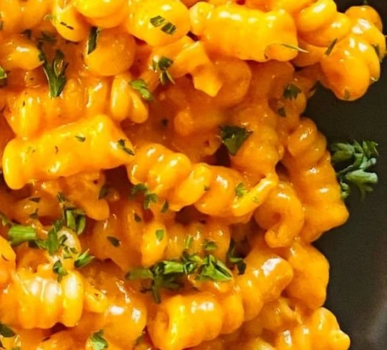Bowl of Gochujang Pasta topped with fresh herbs and vegetables