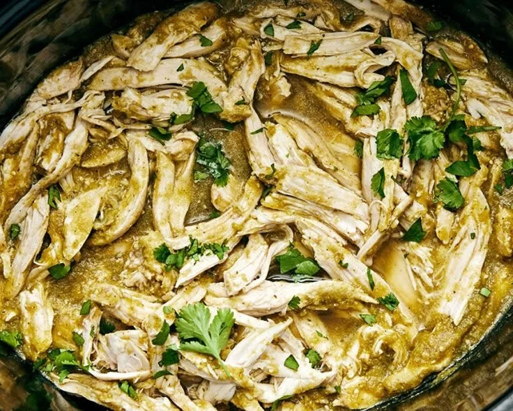 Green Sauce Crockpot Chicken served in a bowl with garnishes.