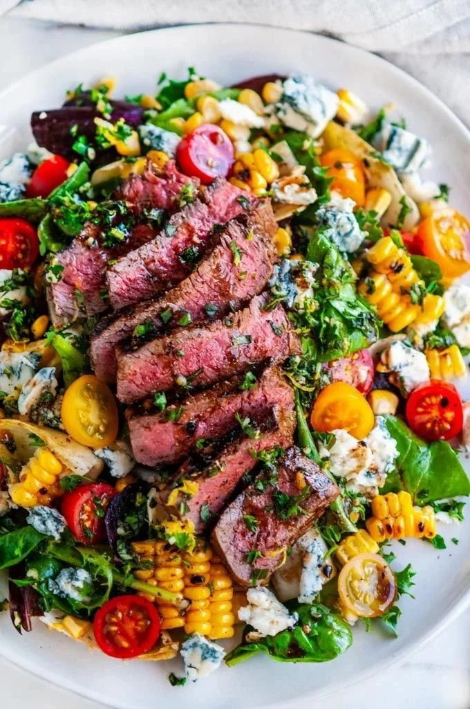 Grilled sirloin steak salad with fresh vegetables and dressing