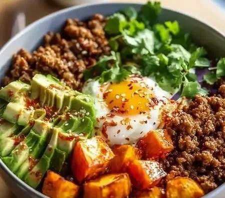 High protein ground beef power bowl with fresh vegetables and grains