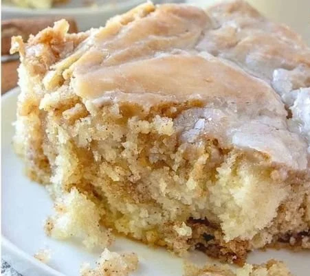Delicious homemade cinnamon roll cake topped with icing and cinnamon swirls.