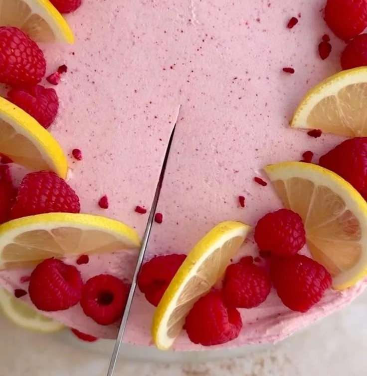 Lemon raspberry cake decorated with fresh raspberries and lemon slices