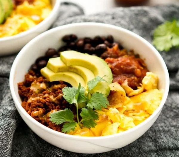 A colorful Mexican Breakfast Bowl featuring eggs, beans, and fresh vegetables.