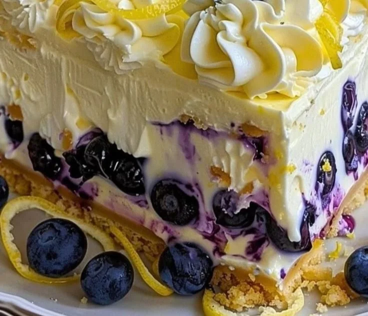 No-bake lemon blueberry cream cake topped with fresh blueberries and lemon slices.