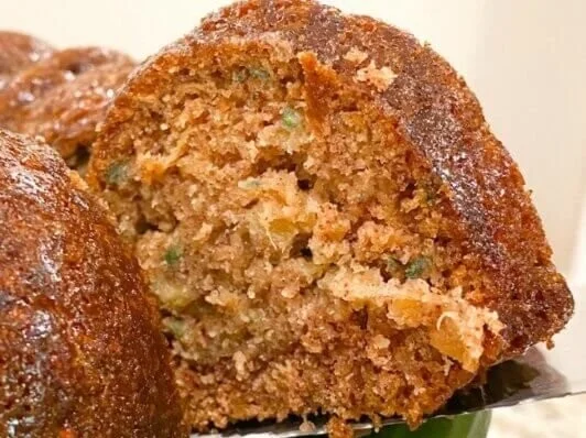 Freshly baked old fashioned zucchini bread sliced on a wooden cutting board.