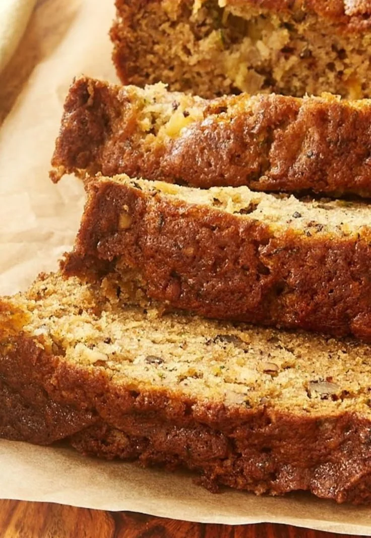 Freshly baked Pineapple Zucchini Bread slice on a wooden table