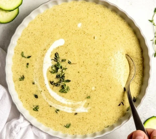 Bowl of creamy Potato Zucchini Soup garnished with herbs
