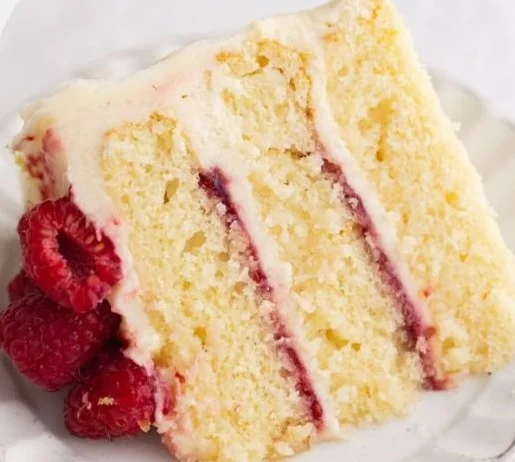 Delicious Raspberry Lemon Cake topped with fresh raspberries and lemon slices