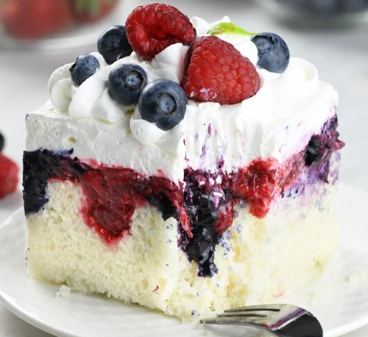 Delicious Summer Berry Poke Cake topped with fresh mixed berries and whipped cream