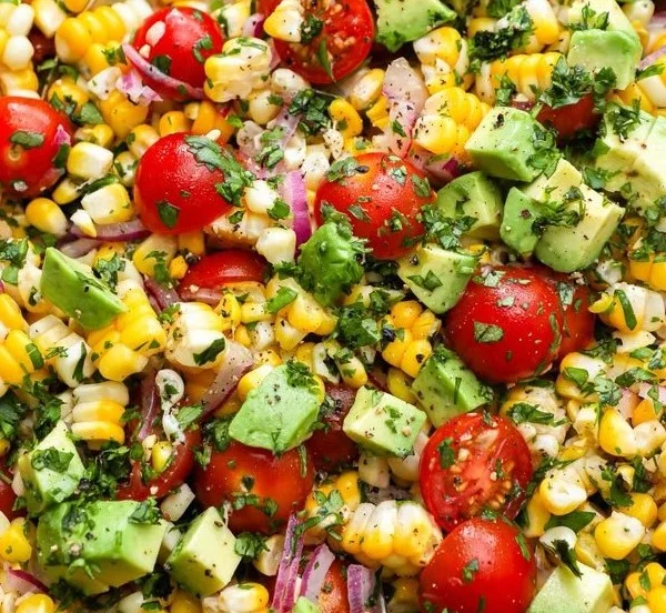 Summer corn salad with avocado in a colorful bowl, fresh and delicious for summer.