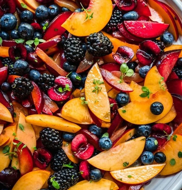 Summer fruit salad with lemon maple thyme dressing in a bowl