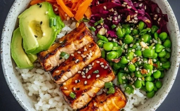 Delicious teriyaki salmon Buddha bowl with fresh vegetables and rice.