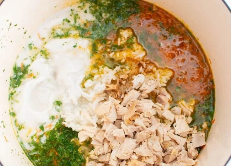Bowl of flavorful Thai Chicken Soup garnished with herbs and spices.