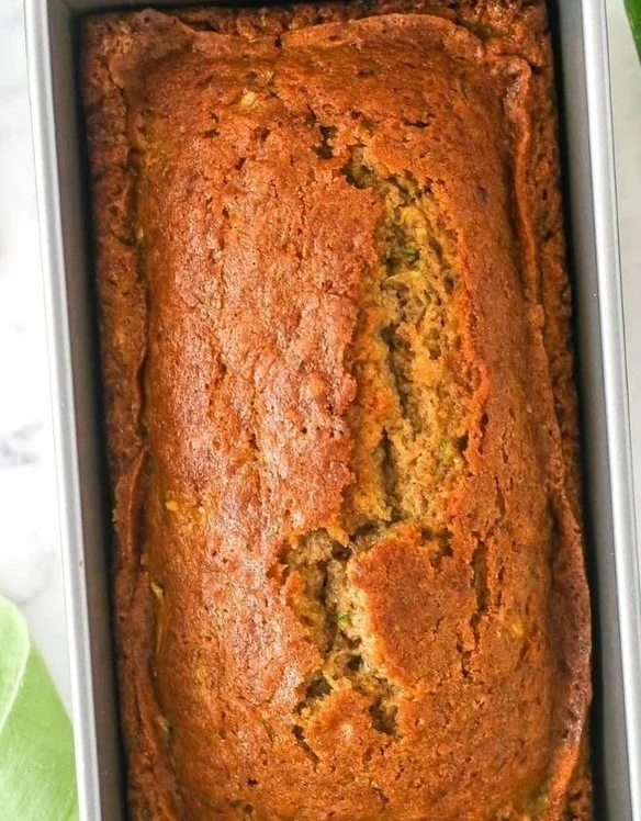 Freshly baked zucchini bread sliced on a wooden cutting board