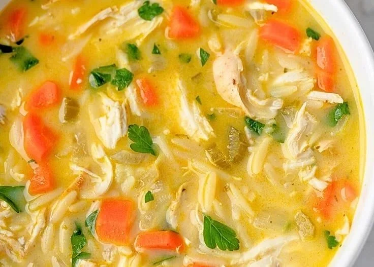 Bowl of authentic Greek lemon chicken soup (Avgolemono) garnished with herbs