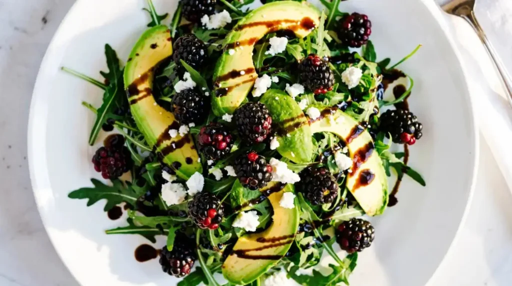 Blackberry Avocado Salad with arugula drizzled with vinaigrette dressing