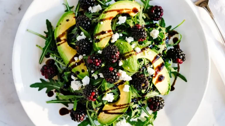 Blackberry Avocado Salad with arugula drizzled with vinaigrette dressing