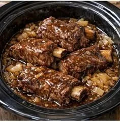 Easy slow cooker beef short ribs served with vegetables and herbs