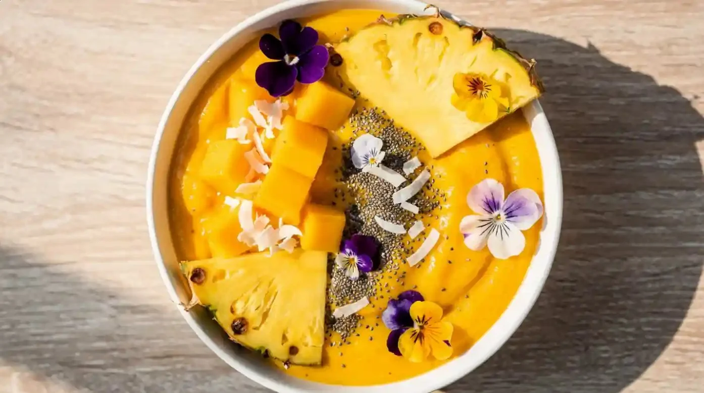 Mango Pineapple Smoothie Bowl topped with fresh fruits and seeds